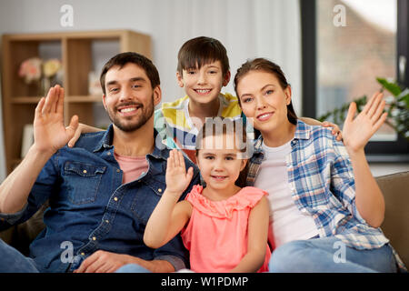 Portrait von Happy Family winkende Hände zu Hause Stockfoto