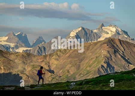 Frau wandern vor der Gletscher Berge des Ecrins, See Lac du Schlange, Dauphine, Dauphiné, Hautes Alpes, Frankreich Stockfoto