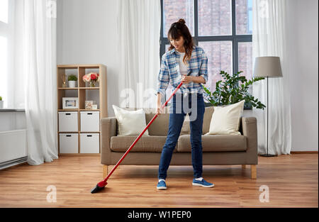 Asiatische Frau mit Besen fegen und Reinigung Stockfoto
