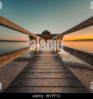 Auf dem Steg auf dem Bootshaus bei einem romantischen Sonnenuntergang, Stegen, Bayern, Deutschland Stockfoto