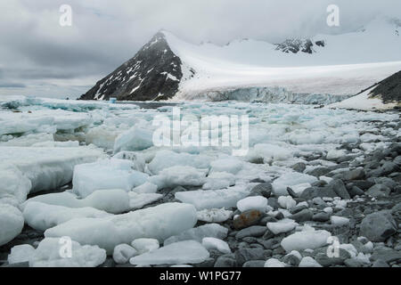 Meereis spült am Ufer in einer Bucht seitig von mittleren schneebedeckte Berge, Base Orcadas, South Orkney Inseln, Antarktis Stockfoto