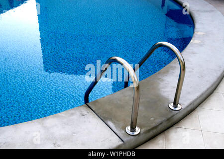 Schnappen Sie sich Bars Leiter im blauen pool Stockfoto