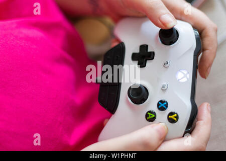 Einblick in die Hände des weiblichen Person halten und Spielen mit weißen Microsoft Xbox 1-Controller Stockfoto