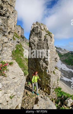 Frau wandern zwischen Felsspitzen in Richtung Hoher Ifen, Hoher Ifen, Allgaeuer Alpen, Tal der Walsertal, Vorarlberg, Österreich Stockfoto