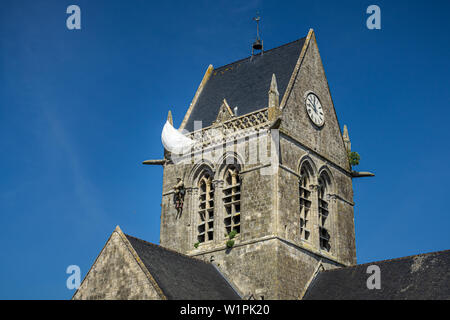 Der Amerikaner John Steele Fallschirmjäger Denkmal an der Kirche auf dem Dach ot Sainte-Mère l'Eglise, Normandie, Frankreich. Stockfoto