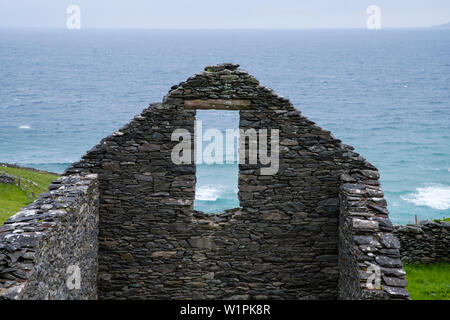 Die Wellen des Atlantik durch das Fenster der Reste einer alten Gebäude aus Stein ohne ein Dach aus beim Gehen die Dingle Way gesehen Stockfoto