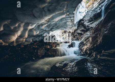 Mountain River durch alte Schneehöhle, E5, Alpenüberquerung, 1. Stufe zu Kemptnerhütte Sperrbachtobel Oberstdorf, Allgäu, Bayern, Alpen, Deutschland Stockfoto