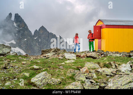 Mann und Frau wandern stand vor der Biwak, Giro di Monte Viso, Monte Viso, Monviso, Cottischen Alpen, Piemont, Italien Stockfoto