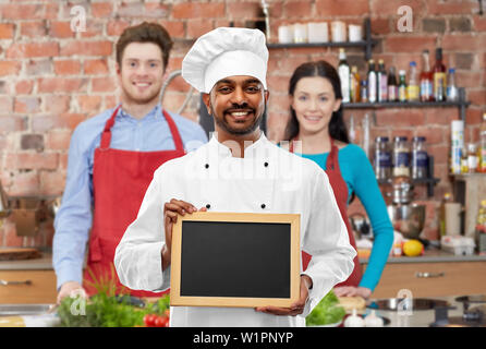 Happy indischen Koch mit Tafel am Kochkurs Stockfoto