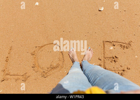 Liebe Wort Konzept mit einem Jungen barfuß Frau an einem Sandstrand. Stockfoto