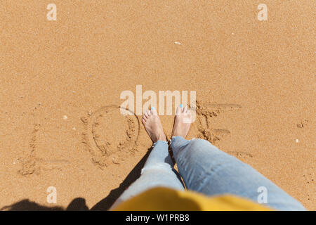 Liebe Wort Konzept mit einem Jungen barfuß Frau an einem Sandstrand. Stockfoto