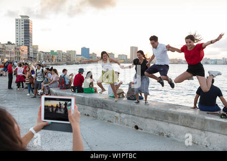 Touristen und Einheimische und Fischer am Malecon, Frau Bilder aufnehmen mit Tablet, historische Altstadt, Zentrum, Altstadt, Habana Vieja, Habana Centro, f Stockfoto