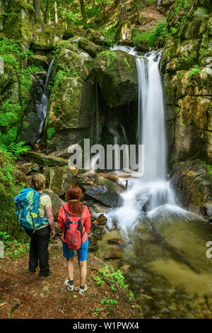 Zwei Frauen wandern in Richtung Wasserfall, Wasserfall, Hoellbach Albsteig, Schwarzwald, Baden-Württemberg, Deutschland Stockfoto