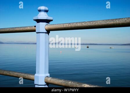 Blick durch das Geländer der Morecambe Bay Promenade und Stein Jetty, Lancashire, Großbritannien Stockfoto