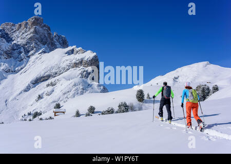 Zwei Personen backcountry Skiing aufsteigend zu Medalges, Geisler Bereich im Hintergrund, Medalges, Naturpark Puez-Geisler, UNESCO-Weltkulturerbe Dol Stockfoto