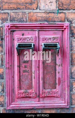 Alte ausgediente Bauen in der Wand porto Maschine Briefmarken in Crewe, Cheshire Vereinigtes Königreich Stockfoto