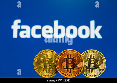 Gold Bitcoin Münzen mit der Facebook Logo auf Hintergrundbild Stockfoto