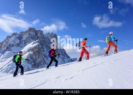 Mehrere Personen backcountry Skiing aufsteigend zu Medalges, Geisler Bereich im Hintergrund, Medalges, Naturpark Puez-Geisler, UNESCO Weltkulturerbe Stockfoto