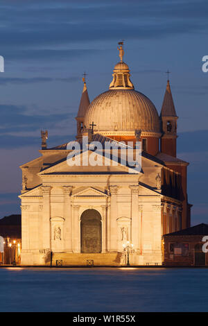 Mit Blick auf die Lagune von Venedig auf der Insel Giudecca mit der beleuchteten Kirche Il Redentore in Blau bei Nacht, Venedig, Venetien, Italien Stockfoto