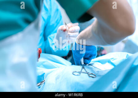 Closeup Chirurg Hand in Hand gelten. Gruppe von Chirurgen im Operationssaal mit Chirurgie. Medizinischen Hintergrund. Stockfoto