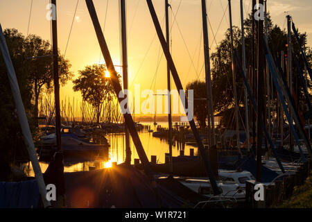 Ansicht zwischen Segel Masten auf Elektro- und Segelboote in das Feld Port in den Sonnenuntergang am Chiemsee Wieser Stockfoto