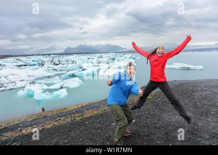 Reisen Menschen Spaß springen auf Island begeistert von Gletschersee Jökulsárlón Gletscherlagune/Glacier Lake. Gerne lustig Touristen genießen Sie einen wunderschönen isländischen Natur Landschaft mit Vatnajökull im Hintergrund. Stockfoto