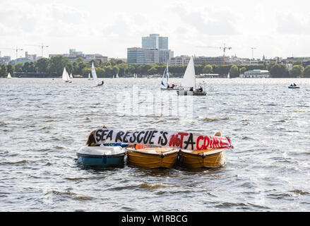 Hamburg, Deutschland. 03 Juli, 2019. Mitglieder der Segeln-Abteilung des FC St. Pauli, die zweite Division Football Club, mit einem Banner mit ea Rettung der Inschrift ist kein Verbrechen!" auf der Außenalster kostenlos Seenotrettung im Mittelmeer demonstrieren. Credit: Daniel Reinhardt/dpa/Alamy leben Nachrichten Stockfoto