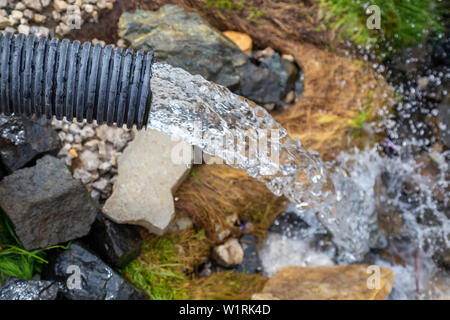 Strom von sauberem Wasser aus tiefen Brunnen ohne Strom. Kühl und frisch Natur Wasser Quelle aus dem Boden. Konzept: Ökologie und Gesundheit. Stockfoto