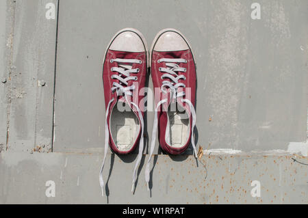 Paar verschlissen vintage Red Old canvas Turnschuhe an Grau lackiert Zinnoberfläche Hintergrund Stockfoto