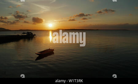 Bunte helle Wolken bei Sonnenuntergang über dem Meer, Luftbild. Spiegelt sich die Sonne auf einer Wasseroberfläche. Sonnenuntergang über dem Meer. Balabac, Palawan, Philippinen Stockfoto