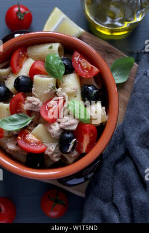 Pasta mit Thunfisch, Tomaten, schwarze Oliven und Parmesan auf dunklem Hintergrund. Ansicht von oben mit der Kopie. Stockfoto