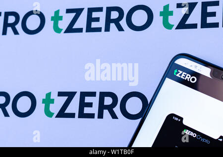 TZero Logos auf die Broschüre und das Smartphone mit dem tZERO Crypto App Screenshot. Stockfoto