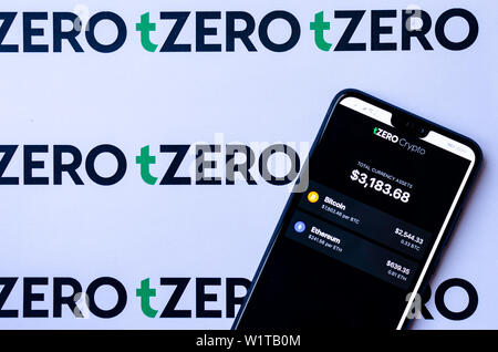 TZero Logos auf die Broschüre und das Smartphone mit dem tZERO Crypto App Screenshot. Stockfoto