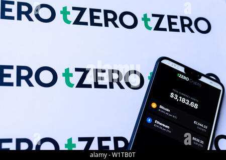 TZero Logos auf die Broschüre und das Smartphone mit dem tZERO Crypto App Screenshot. Stockfoto