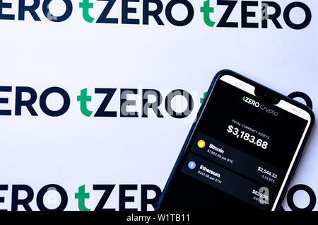 TZero Logos auf die Broschüre und das Smartphone mit dem tZERO Crypto App Screenshot. Stockfoto