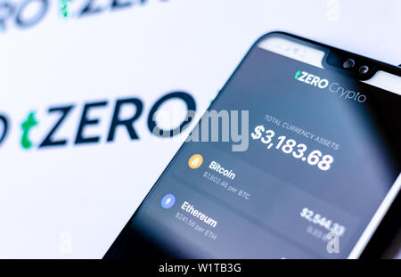 TZero Logos auf die Broschüre und das Smartphone mit dem tZERO Crypto App Screenshot. Stockfoto