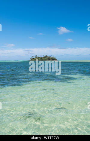Blick auf einen winzigen Palm - überdachte motu Insel mit viel Wasser im Vordergrund und blauen Himmel über, Rarotonga, Cook Inseln, Südpazifik Stockfoto