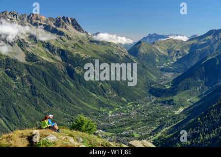 Ein Mann und eine Frau sitzt auf der Rückseite spitz, Chamonix Mont Blanc im Hintergrund, Pyramide, Grajische Alpen, Savoyer Alpen, Savoie, Frankreich Stockfoto