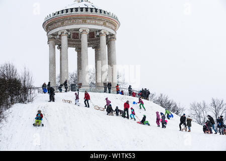 Rodeln bei Schneefall am Monopteros, Englischer Garten, München, Deutschland Stockfoto