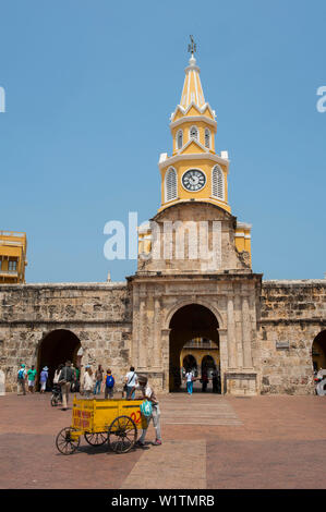 Ein Anbieter mit Wagen geht durch die Puerta del Reloj (auch Torre del Reloj oder Boca del Puente), die Hauptstraße der Stadt eingang, Cartagena, Bolivar, Kolumbien, Stockfoto