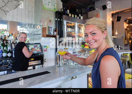 Junge Frau trinkt einen Drink im Pub Urban Deli AB SOFO, Stockholm, Schweden Stockfoto