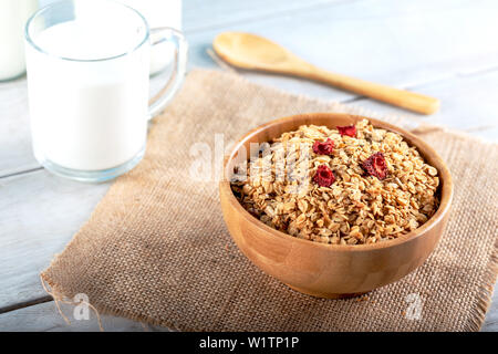 Haferflocken oder Haferflocken in Schüssel mit Holz- spoonsand Flasche Milch für den Hintergrund. Stockfoto