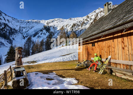 Frau backcountry Skiing in einer Pause an der Hütte, Plankowitzspitze, Radstädter Tauern, Kärnten, Österreich Stockfoto