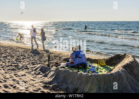 Paar in einer Sandburg am Strand von Warnemünde, Ostseeküste, Mecklenburg-Vorpommern, Deutschland Stockfoto