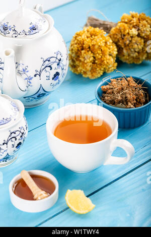 Tasse Linden Linden Tee, getrocknete Blumen in Schale mit Honig und Zitrone auf Holz- Hintergrund. Stockfoto