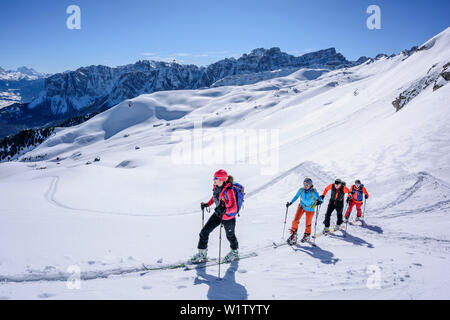 Mehrere Personen backcountry Skiing aufsteigend zu Peitlerkofel, Geisler Bereich im Hintergrund, Peitlerkofel, Naturpark Puez-Geisler, UNESCO-herit Stockfoto