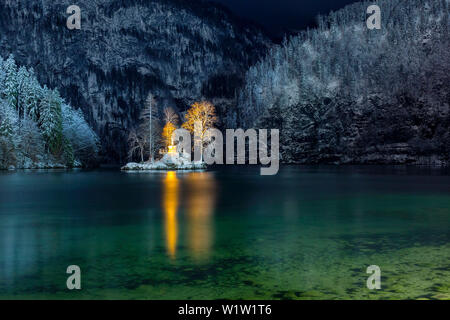 Die kleine Insel in der Königssee mit beleuchteten John Christian Lieger Statue im Winter Bergkulisse Stockfoto