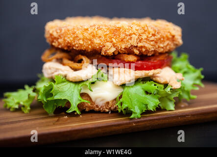 Sushi Burger mit einer Vielzahl von schmackhaften Zutaten auf einem dunklen Hintergrund Stockfoto