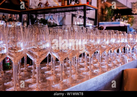 Elegante leere Zeile der Weingläser. Viele leere Glas auf Bar bereit, Wein zu füllen. saubere Gläser im Restaurant. Gläser auf Zähler in bar. Selektiver Fokus Stockfoto