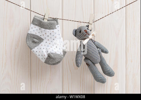 Neue Baby Socken hängen auf Wäscheleine über Holz Hintergrund, Kind und Baby Konzept Stockfoto